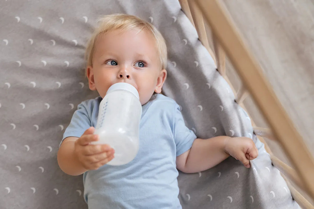 Baby holding milk bottle
